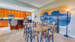 A modern kitchen with wooden cabinets and a dining area with a large table and chairs.