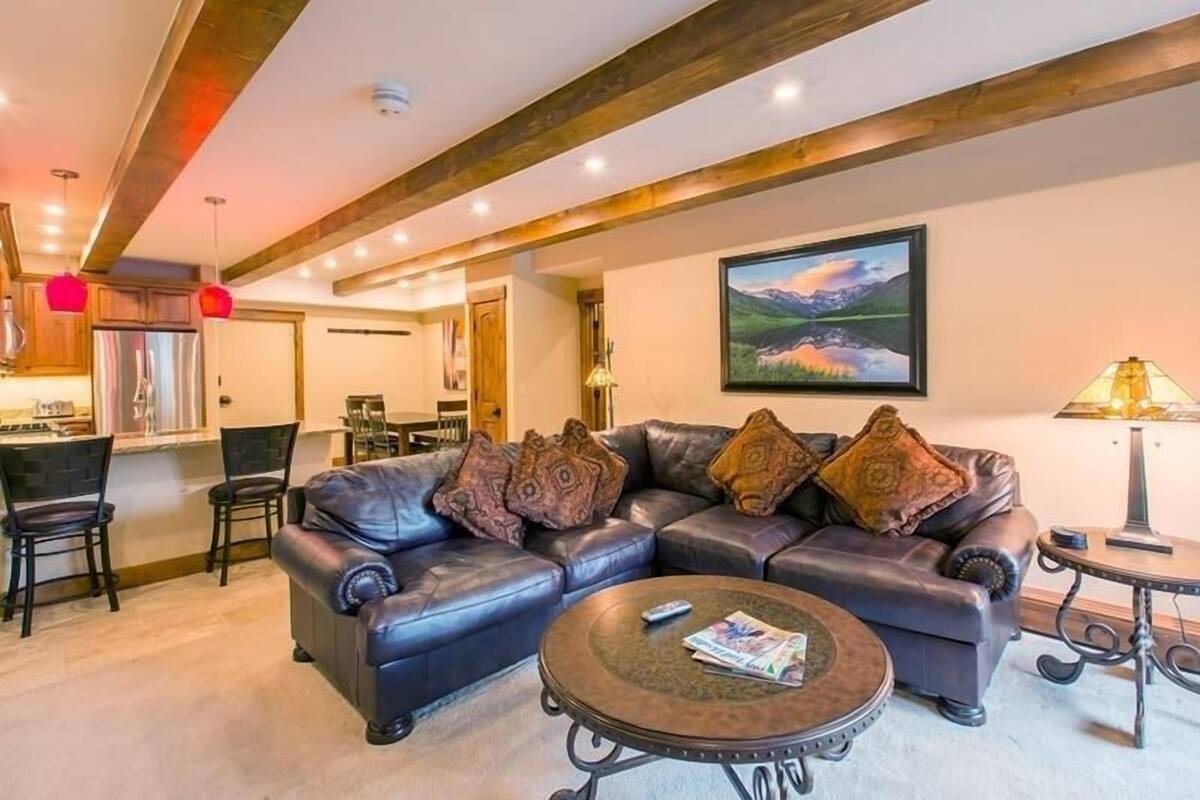 Een moderne woonkamer met een modulaire bank, een salontafel en een eethoek met stoelen.