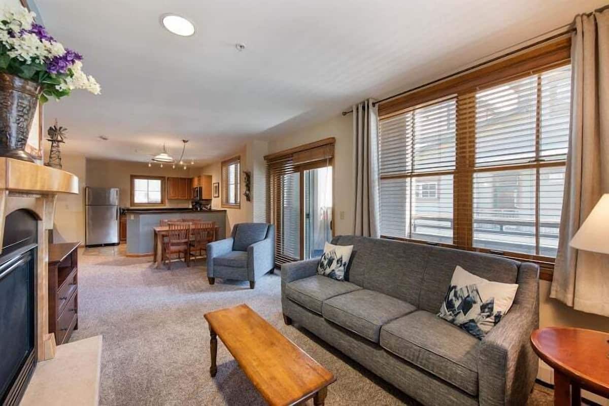 A living room with a sofa, a wooden coffee table, and a dining area with a table and chairs.