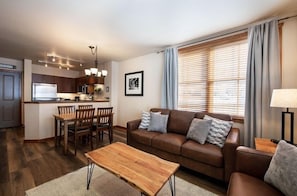 A modern apartment with a kitchen, dining area, and living room. - Zephyr Mountain Lodge Condos (Winter Park)