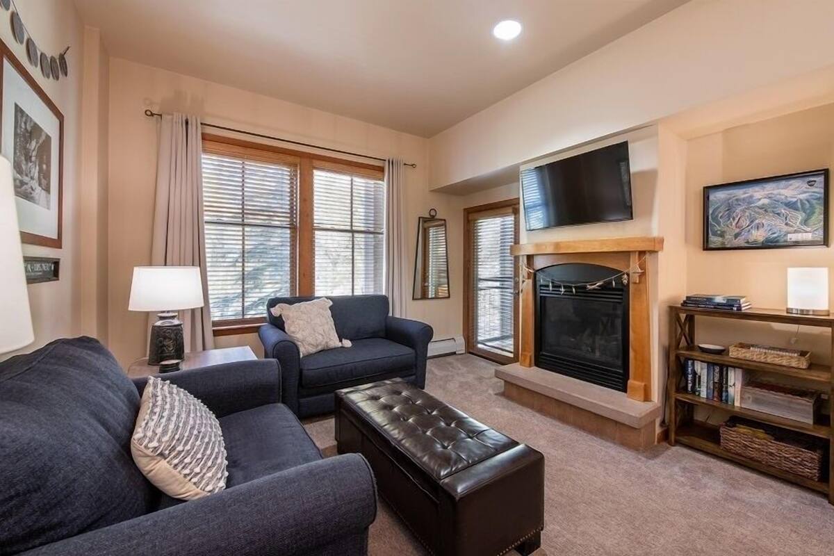 A living room with a fireplace, a sofa, a coffee table, and a television.
