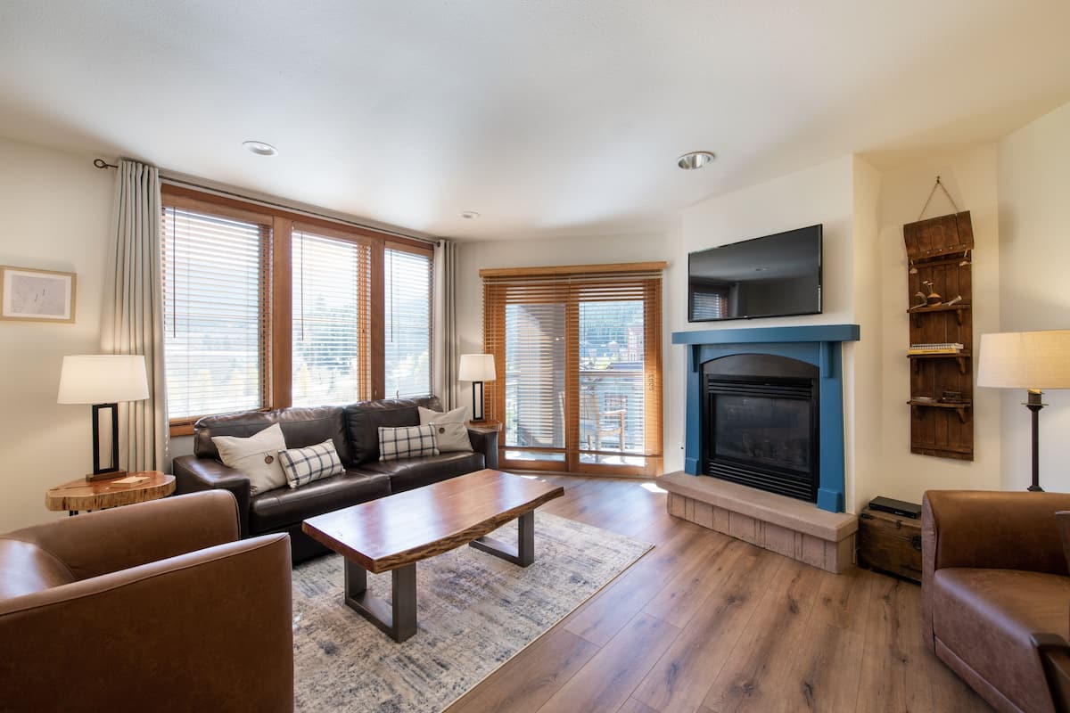 A living room with a fireplace, a sofa, a coffee table, and a television.