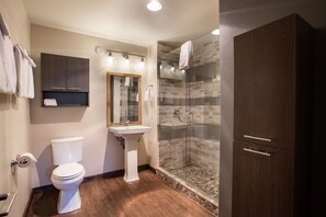 A modern bathroom with a toilet, sink, and glass shower enclosure. - Winter Park CO Condos - Zephyr Mountain Lodge (Winter Park)