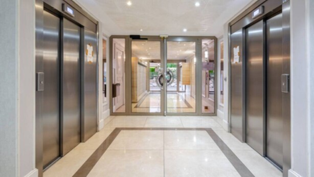 A hallway with two elevators, a glass door entrance, and a tiled floor. - Escapade Exotique-Private Terrace-Love&Jacuzzi (Franconville)