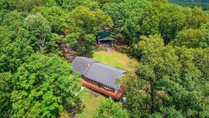 Ein Haus, umgeben von dichtem Wald, mit freiem Blick auf die umliegenden Hügel.
