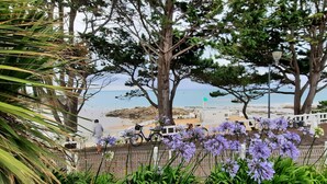 A coastal walkway with a bench, a bicycle, and a view of the beach and sea. - "Les pieds dans l'eau": panoramic sea views and direct beach access! (Saint-Quay-Portrieux)