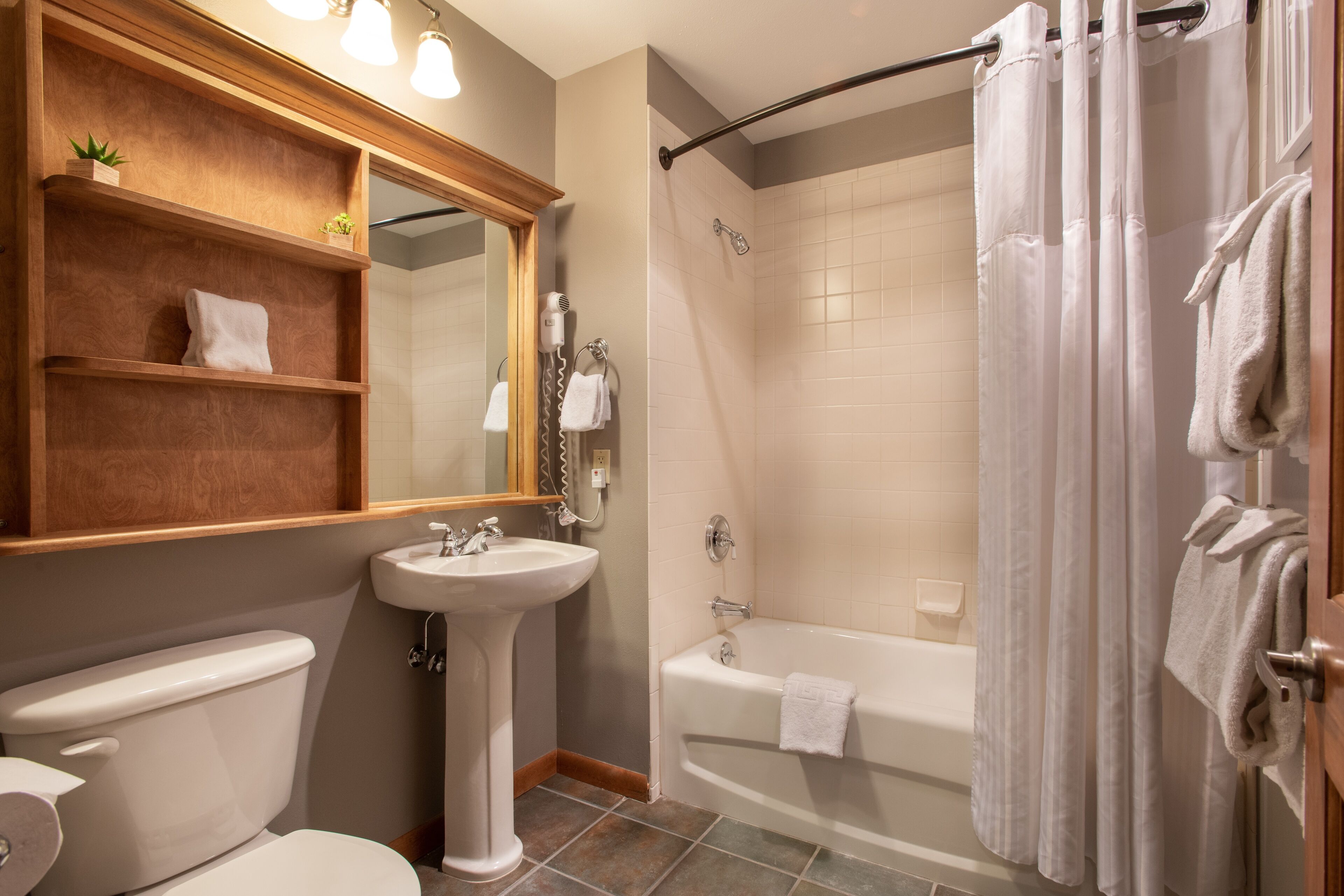 A bathroom with a toilet, sink, and bathtub.