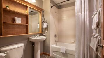 A bathroom with a toilet, sink, and bathtub.