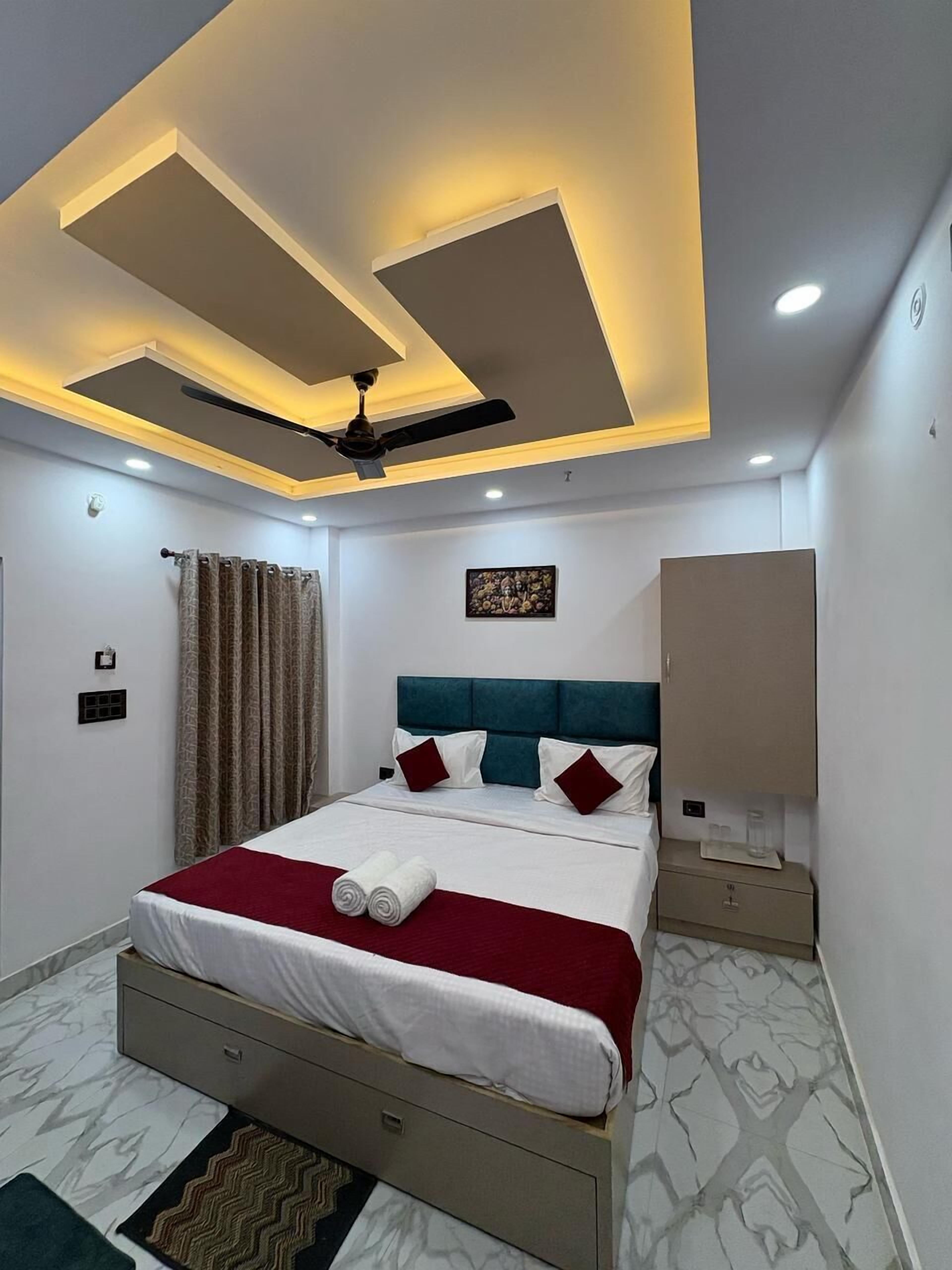 Una habitación de hotel moderna con cama, ventilador de techo y armario empotrado.