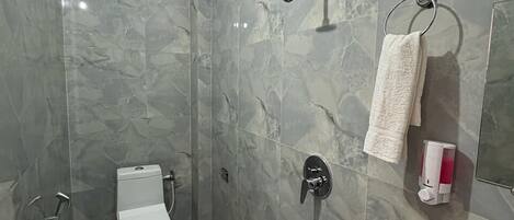 A modern bathroom with a shower, toilet, and sink.