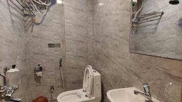 Un baño con inodoro, bidé y lavamanos.