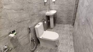 A bathroom with a toilet, sink, and shower.
