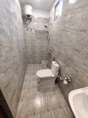Een badkamer met toilet, douche en bad.