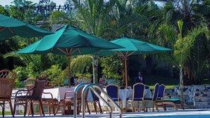 Un espace aménagé au bord de la piscine, avec des sièges et des parasols.