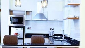 Une cuisine moderne équipée d’un four à micro-ondes, d’une cuisinière et d’un coin repas avec des chaises.