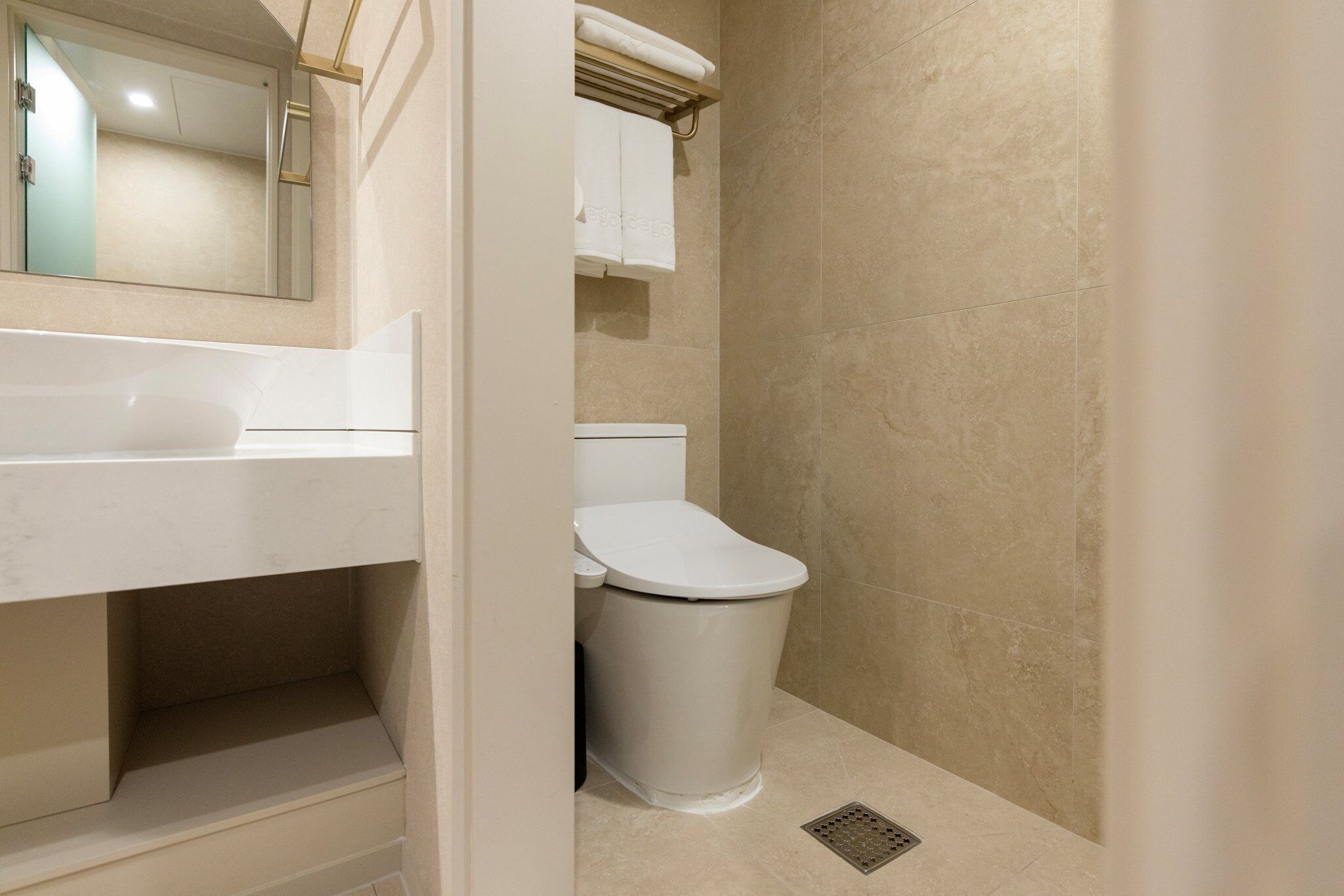 A bathroom with a white toilet, a sink, and a mirror.