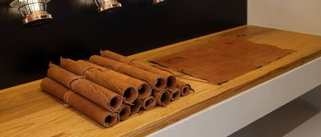 A wooden shelf with rolled-up brown items and a label.