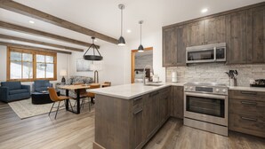 A modern kitchen with wooden cabinets, a built-in oven, and a microwave. - Two Bedroom Condos at Zephyr Mountain Lodge - Winter Park CO (Winter Park)