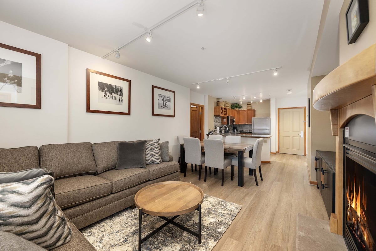 A modern living room with a sofa, coffee table, and framed pictures on the wall.