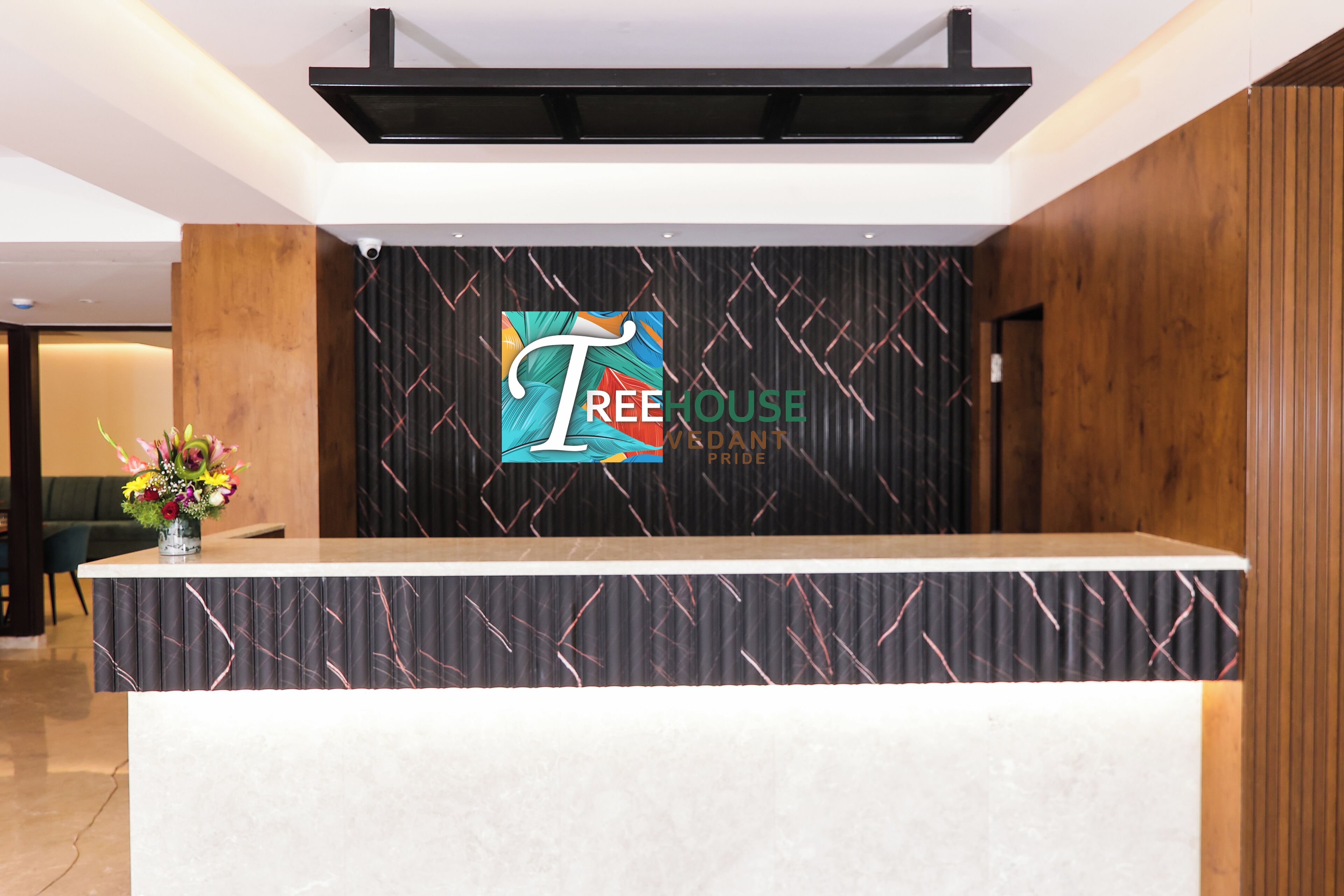 Un mostrador de recepción con un logotipo y la frase "TREE HOUSE PRIDE" en la pared de fondo.