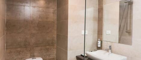 Une salle de bain moderne équipée de toilettes, d’un lavabo et d’une douche.