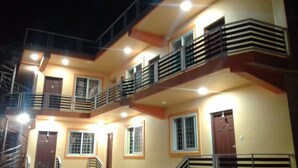 A multi-story building with balconies, multiple windows, and a staircase. - Magic Mist Resort A Boutique Resort (Ooty)