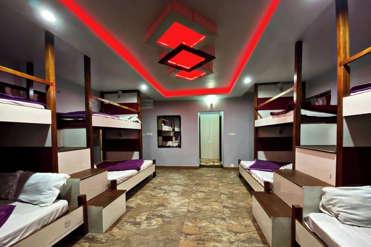 Een kamer met stapelbedden, een deur in het midden en een vloer met een patroon.