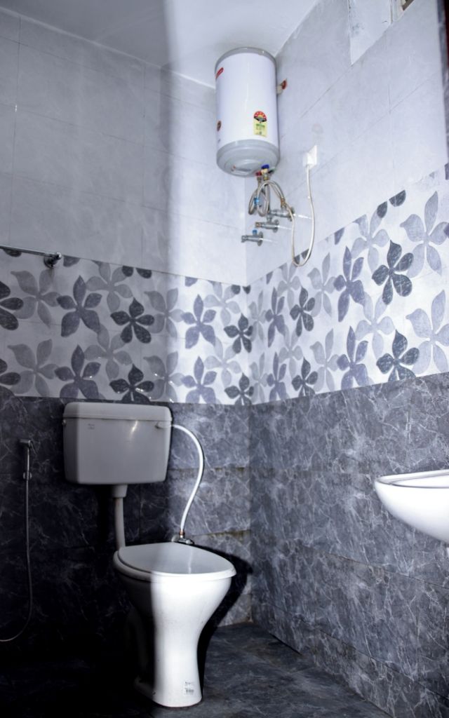 Un baño con inodoro, lavamanos y calentador de agua.