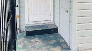 Una puerta blanca con un panel de vidrio, un cerrojo de metal negro y un suelo estampado en azul y beige.