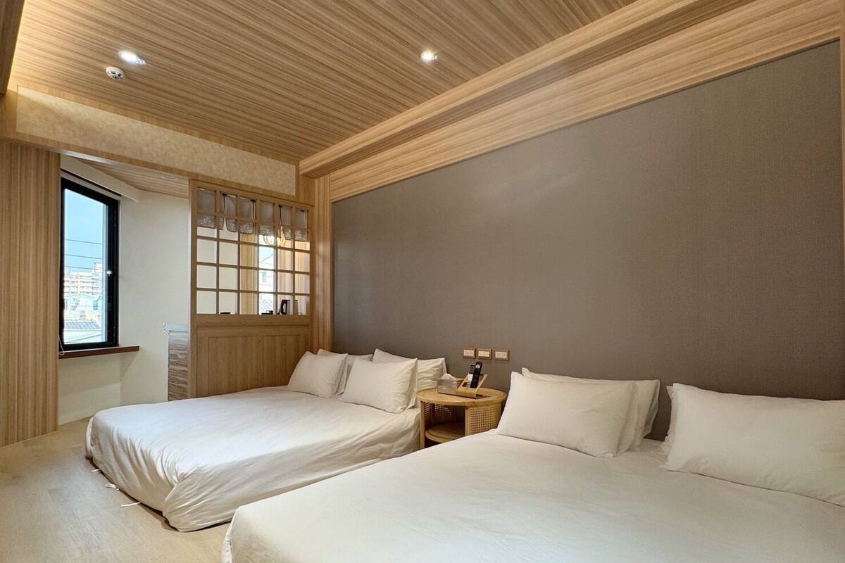 Une chambre d’hôtel avec deux lits, une fenêtre donnant sur un beau paysage et un plafond en bois.