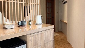 A hotel reception area with a wooden counter, a coffee machine, and a small refrigerator. - yado B&B (Chaozhou)