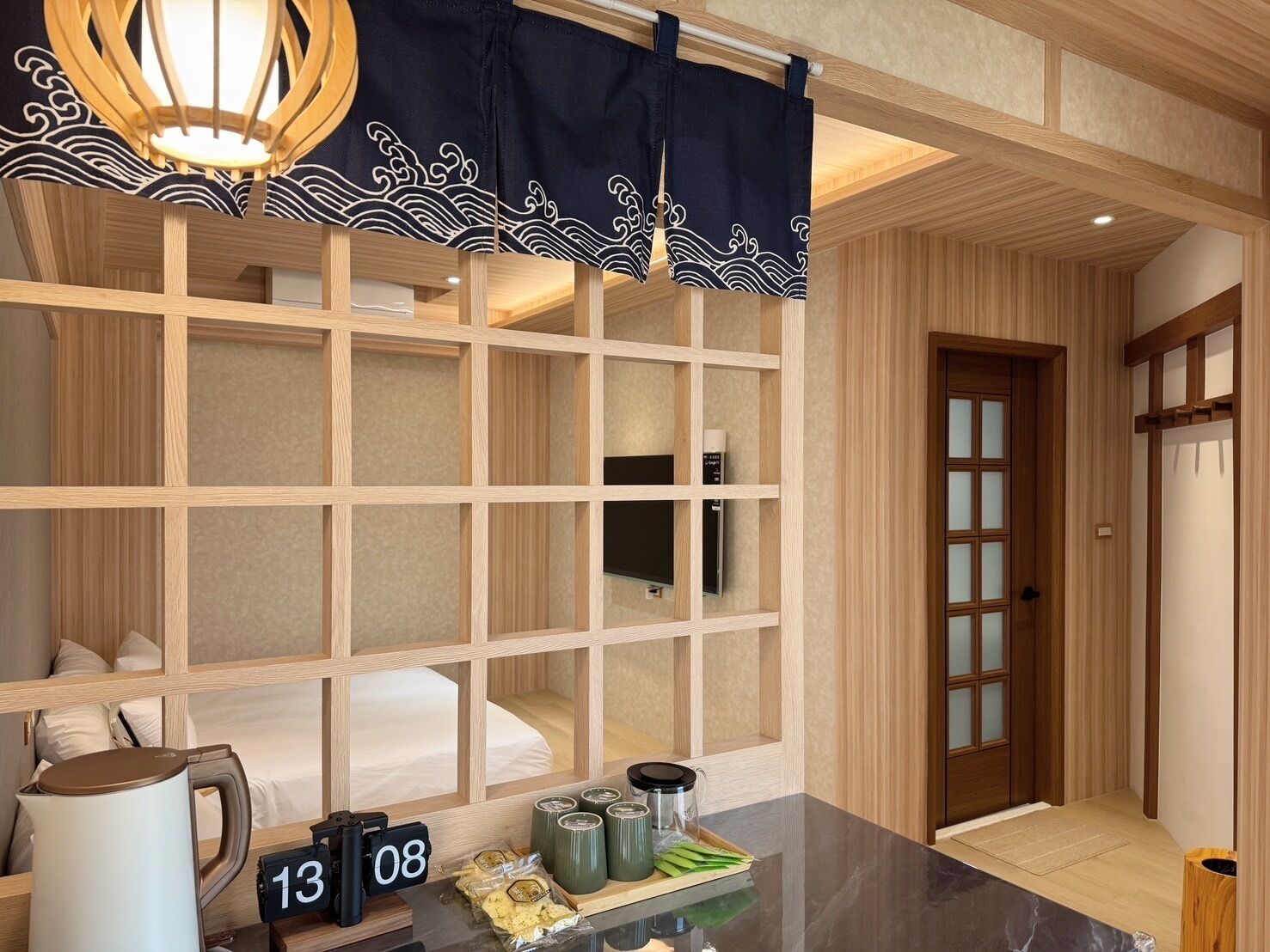 A hotel room with a traditional Japanese-style interior, including a tatami mat floor, shoji screens, and a wooden ceiling.