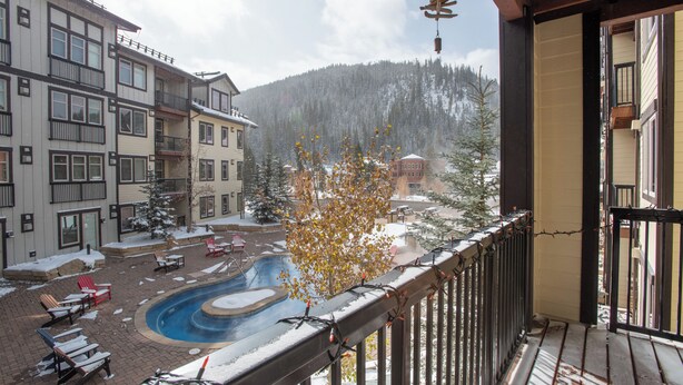 Ein Poolbereich mit Liegestühlen und einer verschneiten Landschaft im Hintergrund.