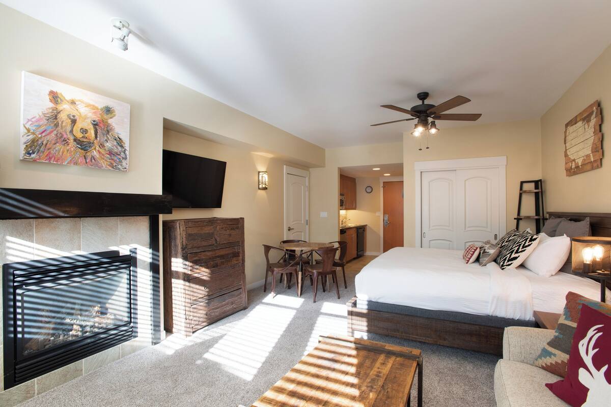 Une chambre moderne avec un lit, une cheminée et un coin repas.