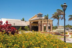 A building with a central pavilion, palm trees, and a fountain. - Serenitys Hideaway Montego Bay (Montego Bay)