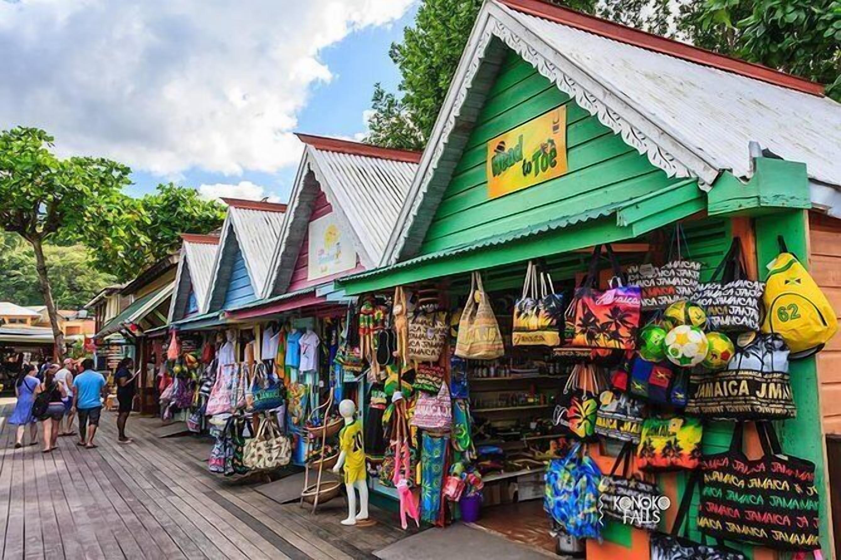 A colorful market street with shops selling bags and souvenirs.