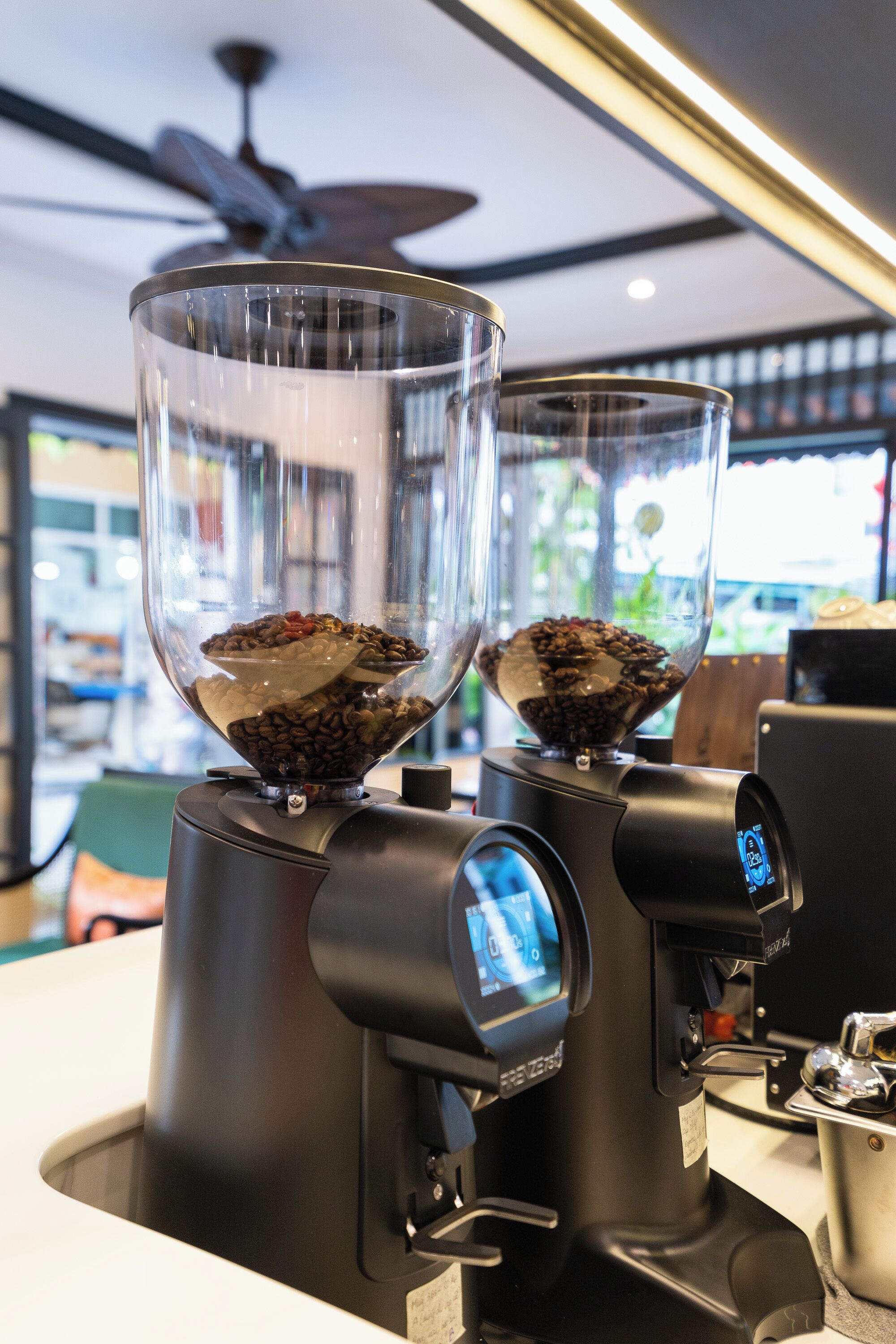 A coffee machine with two transparent containers filled with coffee beans.