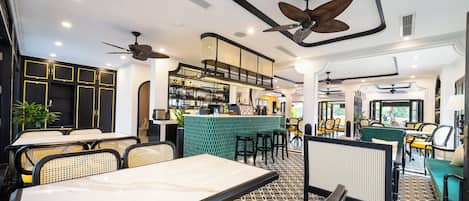 A modern restaurant with high ceilings, ceiling fans, and a bar area.
