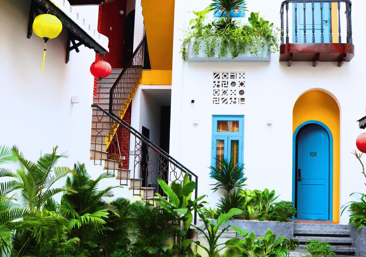 A building with a blue door, a yellow staircase, and red lanterns.
