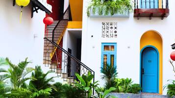 A building with a blue door, a yellow staircase, and red lanterns.