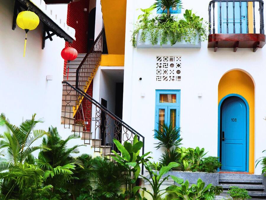 A building with a blue door, a yellow staircase, and red lanterns.