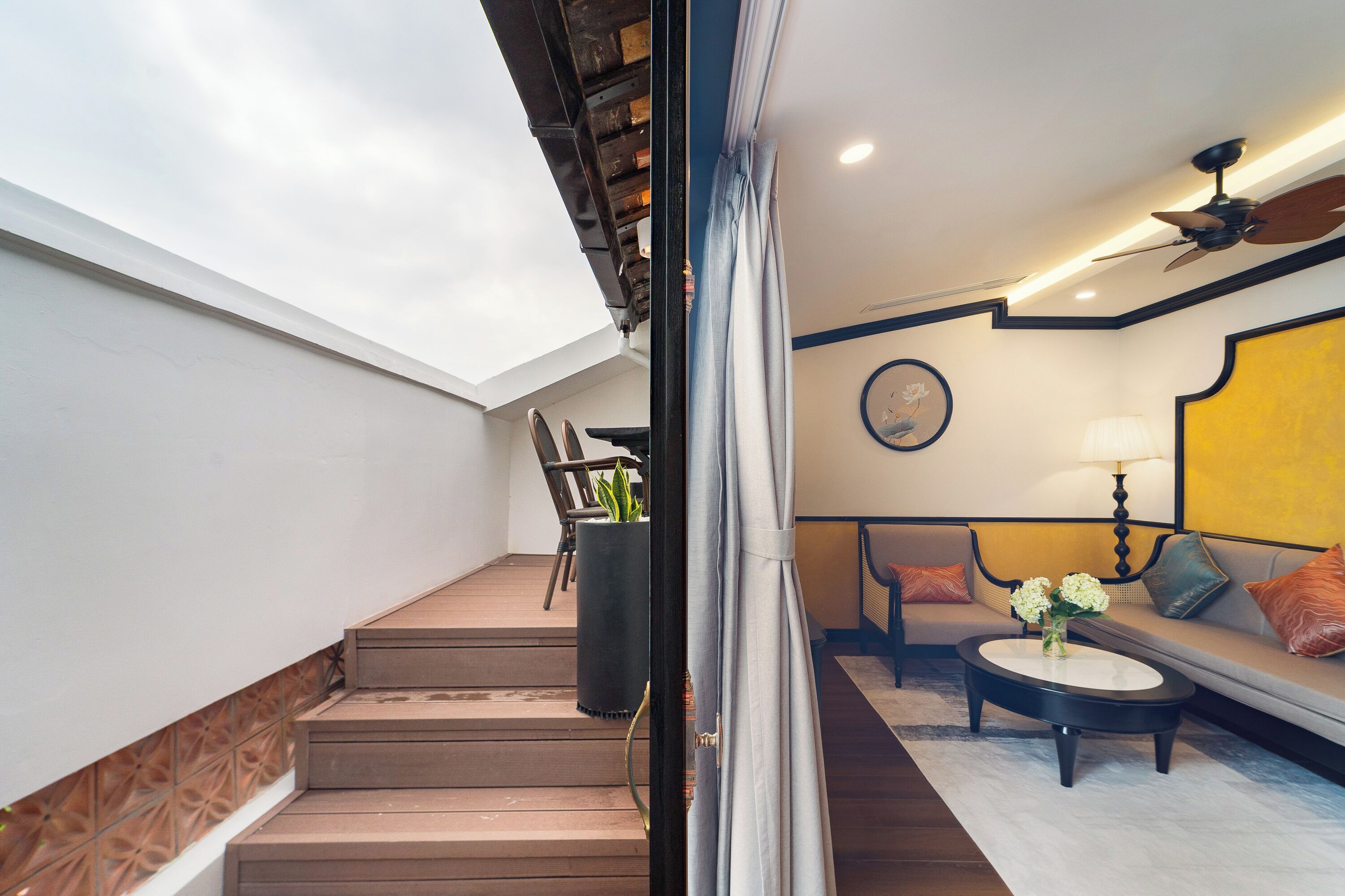 A staircase leading to a living area with a sofa, a coffee table, and a ceiling fan.