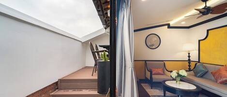 A staircase leading to a living area with a sofa, a coffee table, and a ceiling fan.