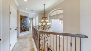 A hallway with a chandelier, a patterned rug, and a door. - Spacious Luxe Home w/ Lake Access in Fort Mohave! (Fort Mohave)