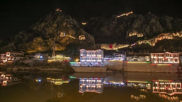 A waterfront hotel with buildings reflected in the water, situated on a rocky hillside with a view of the sea. - SEMAY OTEL (Amasya)