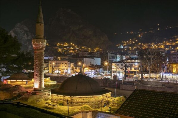 A historic town with a prominent tower and a dome structure, surrounded by buildings and a mountainous backdrop. - SEMAY OTEL (Amasya)