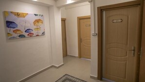 A hallway with a wooden door labeled "301" and a colorful umbrella painting on the wall. - SEMAY OTEL (Amasya)
