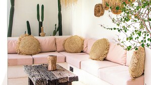 A cozy living room with a pink sofa, a wooden coffee table, and a ceiling fan. - the macan Bingin (Pecatu)