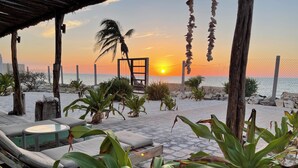 A beachside patio with lounge chairs and planters, overlooking the ocean at sunset. - Bremar Collection Boutique Hotel (Celestún)