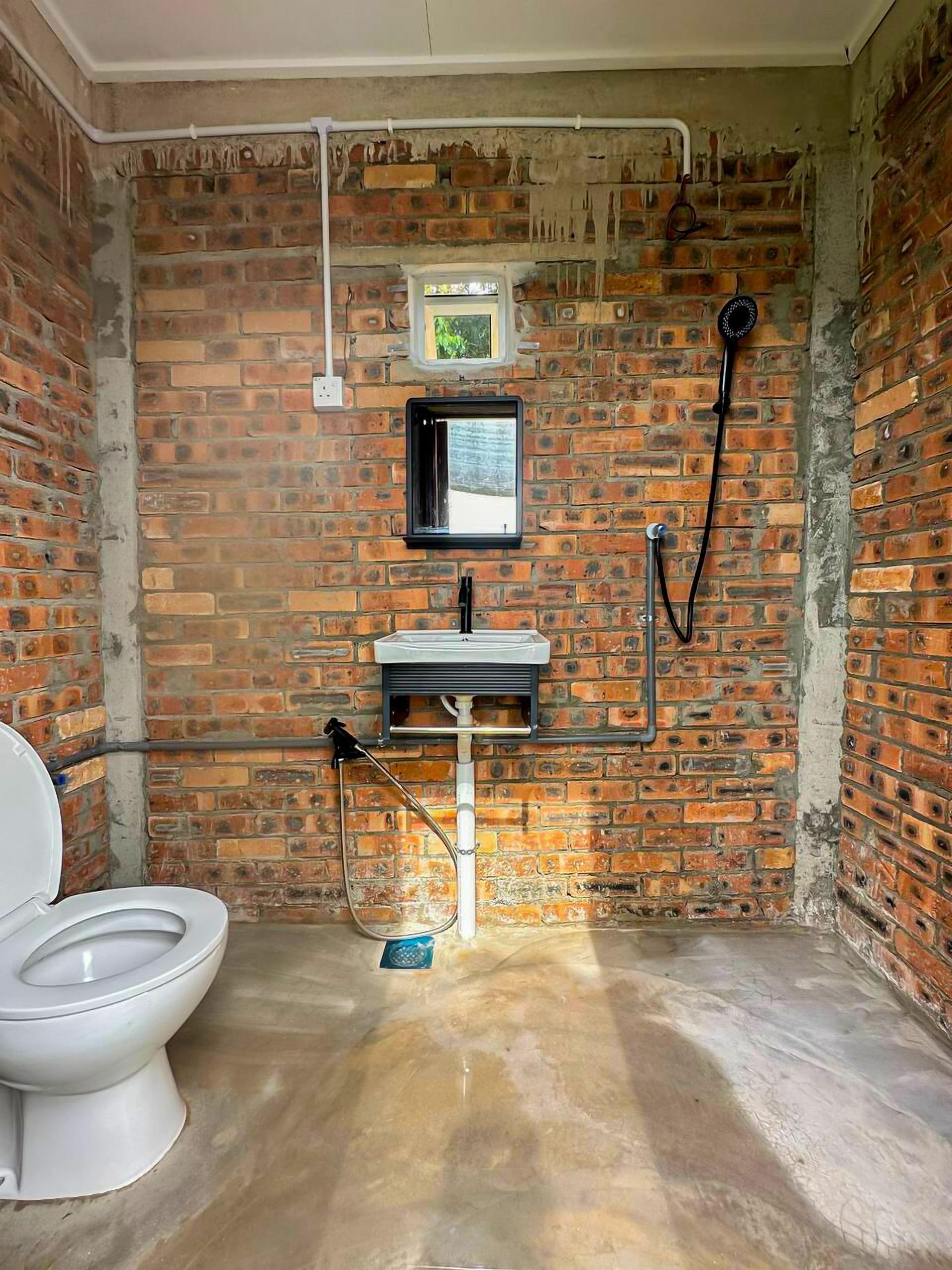 A bathroom with a toilet, a sink, and a shower.